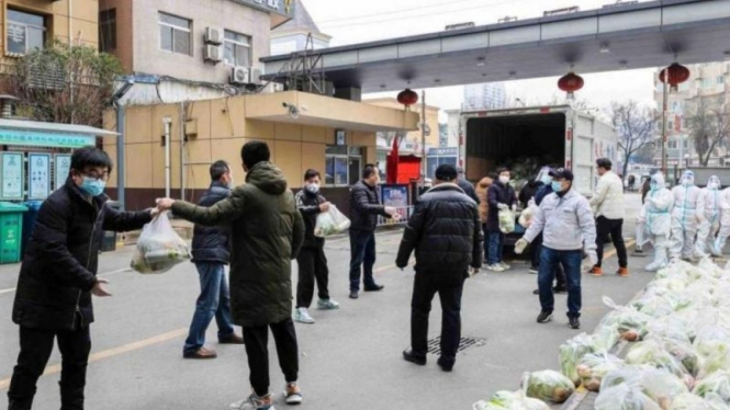 Warga Kota Xian, Provinsi Shaanxi, China, menerima sayur-sayuran dari pemerintah