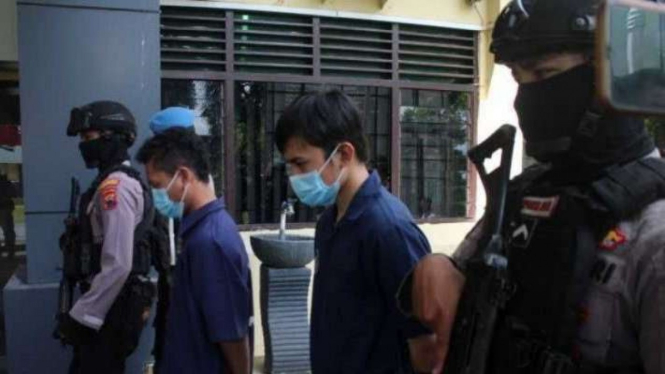 Kedua tersangka kasus penganiayaan kegiatan Diklatsar Menwa Universitas Sebelas Maret (UNS) dikawal oleh polisi saat akan diserahkan kepada Jaksa Penuntut Umum Kejaksaan Negeri di Markas Polresta Surakarta, Senin, 3 Januari 2022.