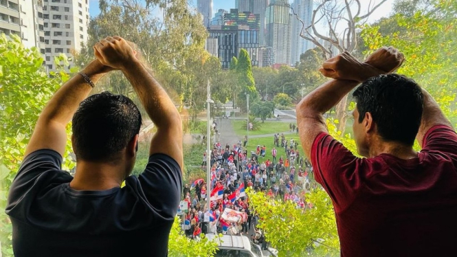 Pengunjuk rasa mengibarkan bendera Serbia di halaman hotel dimana Djokovic dan 32 tahanan lain menjalani penahanan, ada yang sudah hampir 9 tahun. (Supplied:Â Jamal Mohammed)