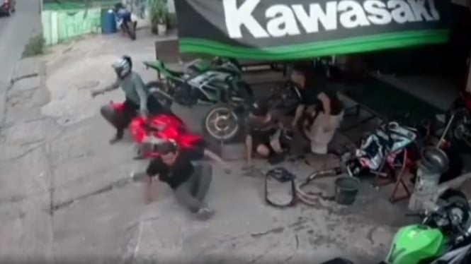 Pengendara motor Ninja jatuh di depan bengkel Kawasaki.