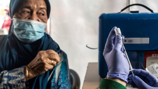 Tenaga kesehatan bersiap menyuntikkan vaksin ke lansia. BBC Indonesia