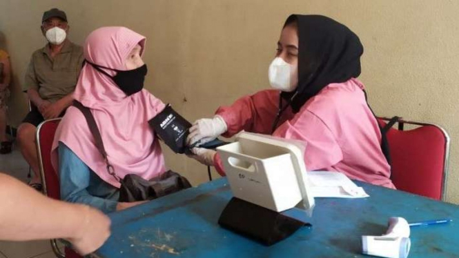 Petugas medis memeriksa kesehatan seorang warga lansia yang akan mendapat vaksinasi dosis penguat di Kota Bandung, Jawa Barat, Kamis, 13 Januari 2022.