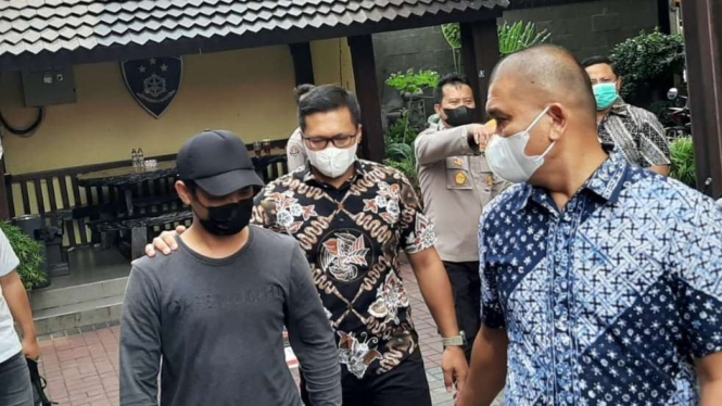 Tersangka HF (memakai topi hitam) usai menjalani pemeriksaan di Markas Polda Jawa Timur di Surabaya.