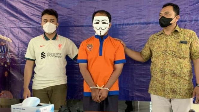 Seorang pengendara sepeda motor berinisial MS (tengah) berusia 49 tahun yang mengacungkan pistol di dekat Kantor Desa Pandanrejo, pada saat dirilis Polres Batu, di Kota Batu, Jawa Timur, Jumat, 14 Januari 2022.