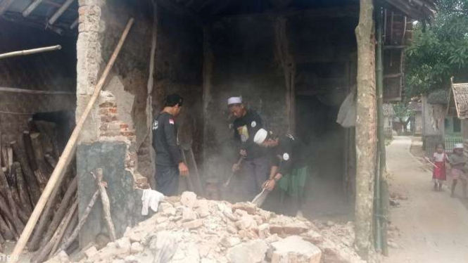 Warga korban gempa di Pandeglang, Banten, membersihkan puing-puing rumahnya yang rusak setelah diguncang lindu pada Kamis, 14 Januari 2022.