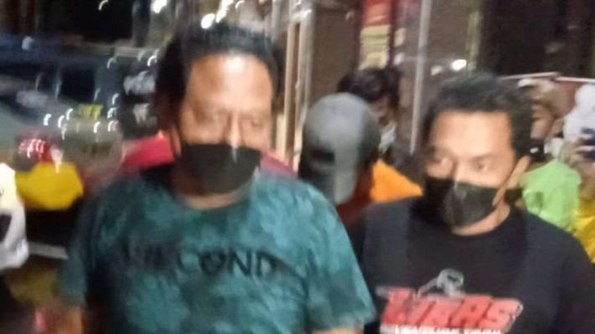 Pria penendang sesajen di lokasi bencana Gunung Semeru tiba di Markas Polres Lumajang, Jawa Timur, Kamis malam, 20 Januari 2022, setelah dipindahkan dari Markas Polda Jawa Timur di Surabaya.
