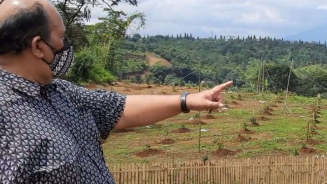 Rio Ricky Damanik petani coklat Desa Bojong Koneng tunjukkan lahannya dirusak.