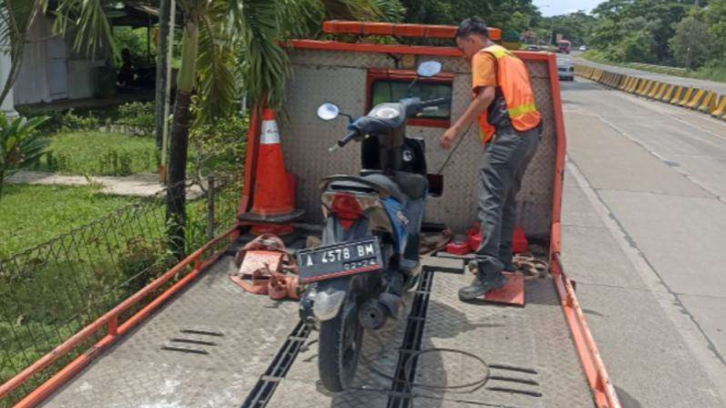 Petugas membawa sepeda motor yang dipakai masuk tol Serang Timur.