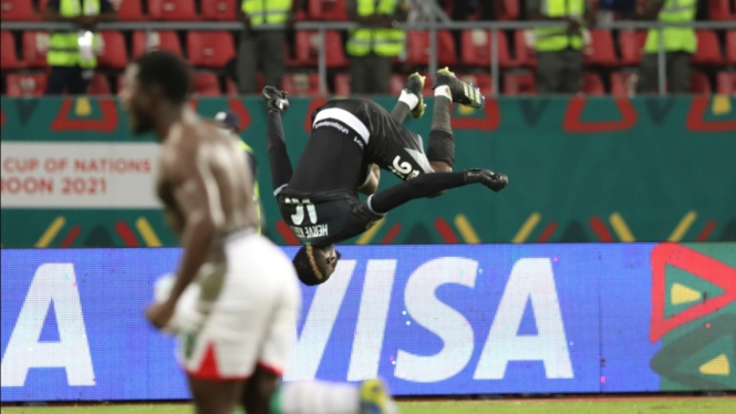 Kiper Timnas Burkina Faso, Herve Koffi, merayakan kemenangan dengan koprol. 