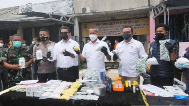 Polisi bersama aparat terkait merilis pengungkapan praktik produksi obat keras ilegal di sebuah ruko Lampu Merah Cikaret (LMC), Cibinong, Kabupaten Bogor, Jawa Barat, Rabu, 26 Januari 2022.
