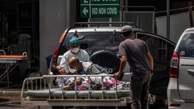 Petugas kesehatan memindahkan seorang pasien, di luar ruang gawat darurat sebuah rumah sakit di Semarang, Jawa Tengah, (02/07). BBC Indonesia