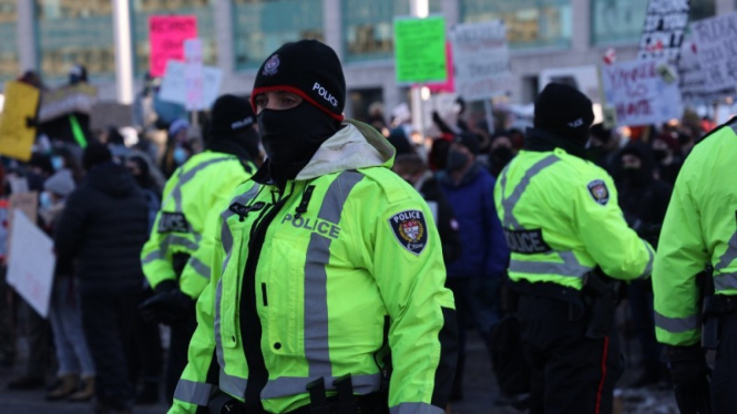 Polisi berjaga-jaga di tengah aksi demonstrasi menentang kewajiban vaksin di Ottawa, Kanada.