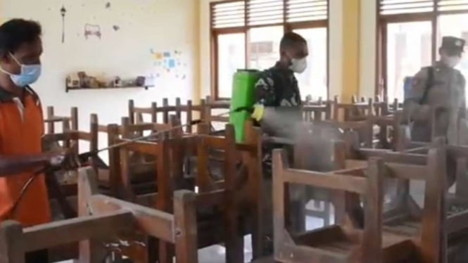 Petugas gabungan di Kendal menyemprotkan disinfektan di sekolah-sekolah.