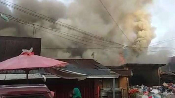 Warga menyaksikan kebakaran yang terjadi di Pasar Bawah, Kota Bukittinggi, Sumatera Barat, Selasa, 15 Februari 2022.