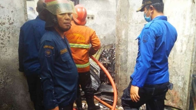 Petugas saat melakukan pendinginan di rumah terbakar di Deli Serdang.