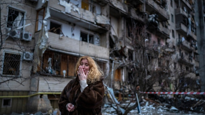 Warga Kota Kyiv Natali Sevriukova menangis di depan rumahnya yang hancur kena serangan roket. (AP:Â Emilio Morenatti)