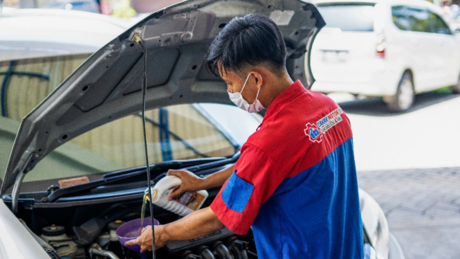 Ilustrasi mobil ganti oli di bengkel.