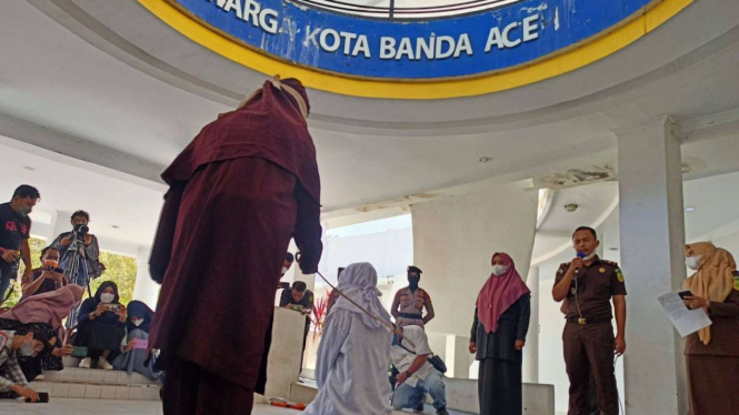 Algojo mengeksekusi cambuk terpidana pelanggar syariat islam di Banda Aceh.