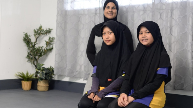 Wakil Kepsek Balaclava State School, Khadeeja Mohammed, bersama muridÂ Filza Afandi dan Kaisara Zafirah bersiap melaksanakan salat di ruang ibadah sekolah yang terletak di Queensland utara. (ABC Far North: Mark RigbyÂ )