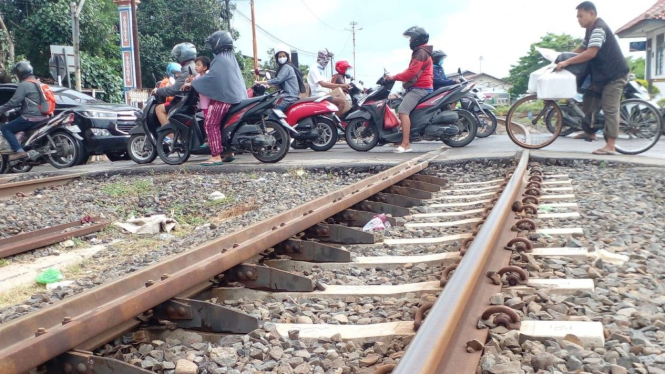 Pengendara sedang melewati perlintasan sebidang rel kereta api di Semarang.