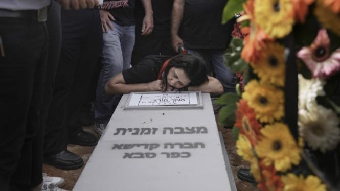 Etty Morad meratapi kuburan anaknya, Tomer Morad, di pemakaman Kfar Saba, Israel, 10 April 2022.