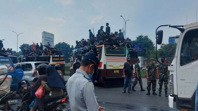 Polisi mengawal aksi demo mahasiswa di Gerbang Tol Gedong, Ciracas, Jakarta