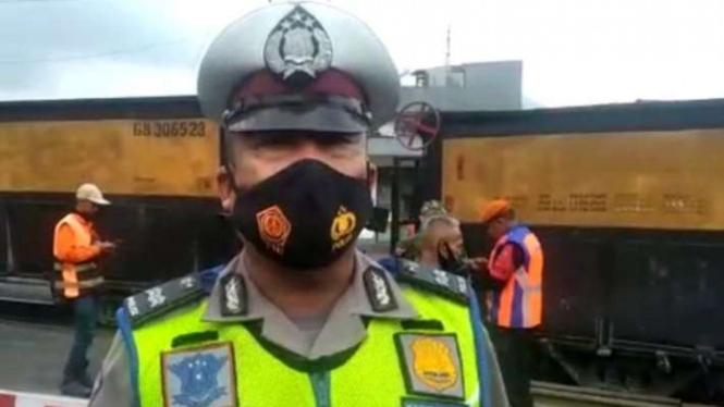 Petugas melakukan pengamanan di lokasi gerbong kereta api anjlok di perlintasan rel Kadungora, Jalan Raya Bandung-Garut, Kabupaten Garut, Jawa Barat, Senin, 11 April 2022.