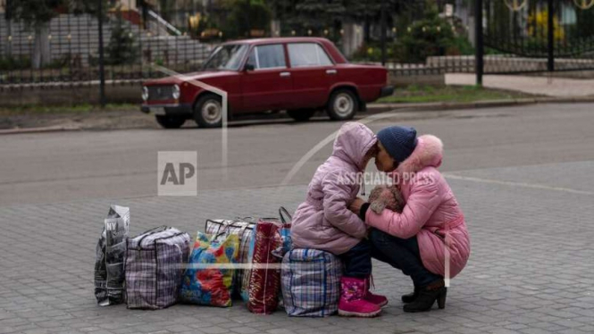 Seorang ibu dan anaknya di Donetsk menunggu bus mau mengungsi ke Ukraina barat