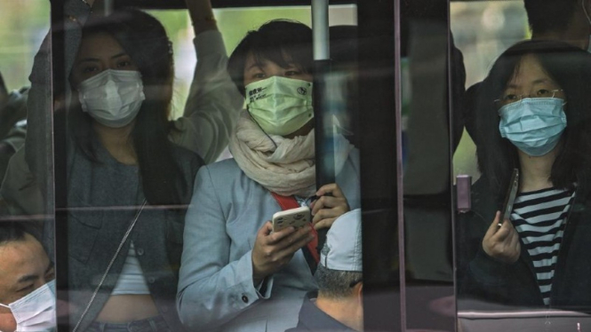 Warga menggunakan masker untuk melindungi diri dari COVID-19 di Beijing, China.