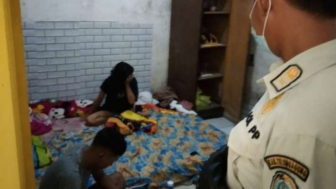 Salah satu pasangan bukan suami istri yang kedapatan berada dalam satu kamar saat digerebek oleh aparat Satpol PP di Tulungagung, Jawa Timur, Kamis, 21 April 2022.
