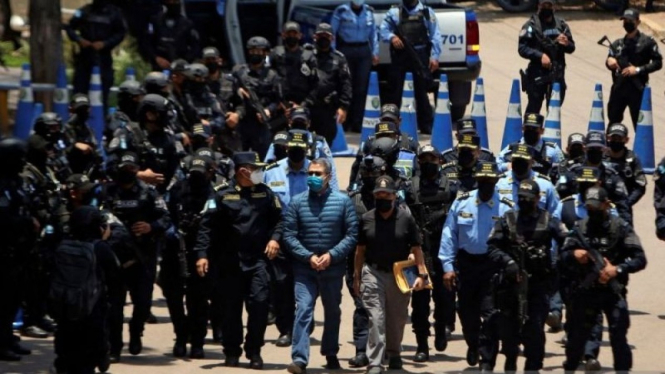 Mantan Presiden Honduras Juan Orlando Hernandez dikawal polisi.