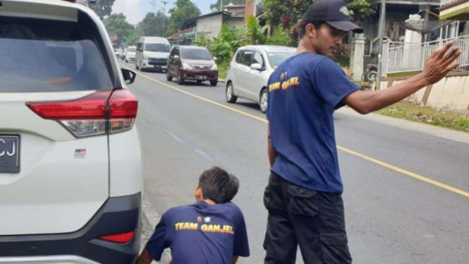Petugas tim pengganjal roda kendaraan bermotor mobil bentukan polisi untuk memfasilitasi arus mudik beroperasi di wilayah Jalan Malangbong, Kabupaten Garut, Jawa Barat, Minggu, 1 Mei 2022.