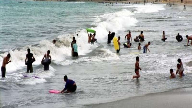 WIsatawan bermain di pantai