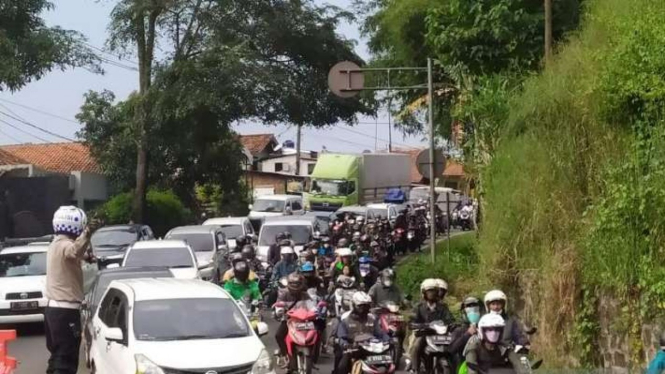 Polisi mengatur lalu lintas pada saat puncak arus balik Lebaran 2022 di Jalan Lingkar Nagreg, Kabupaten Bandung, Jawa Barat, Minggu, 8 Mei 2022.