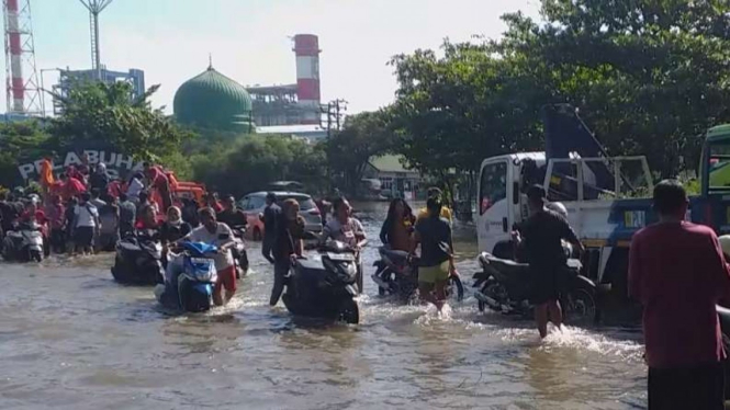Pekerja evakuasi motor saat banjir rob di Semarang.