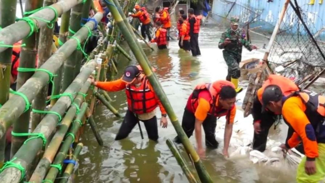 Aparat gabungan bergotong royong membenahi tanggul yang jebol dan menyebabkan banjir rob di kawasan Pelabuhan Tanjung Emas dan sekitarnya di Semarang, Jawa Tengah, Kamis, 26 Mei 2022.