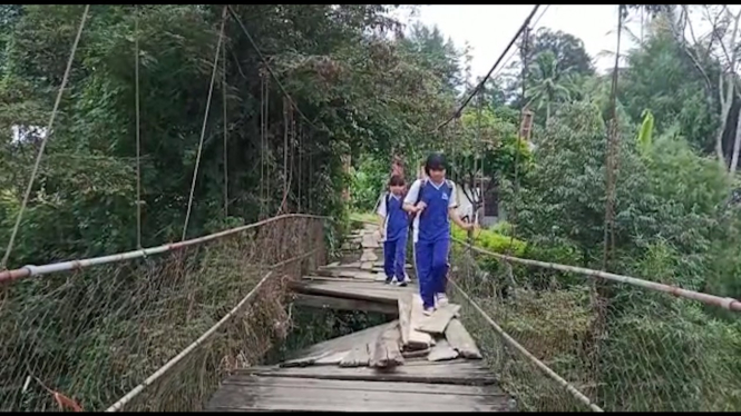 Pelajar nekat melewati jembatan lapuk.