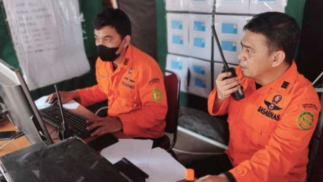 Staf Analis Operasi Pencarian Basarnas Sulawesi Selatan, Majid DJ (kanan), berkomunikasi melalui HT sambil memantau perkembangan pencarian korban KM Ladang Pertiwi 2 melalui monitor di Posko Induk Basarnas, Makassar, Minggu, 29 Mei 2022.