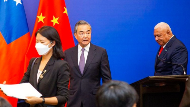 Menteri Luar Negeri China Wang Yi, tengah, muncul di panggung pada pertemuan Men