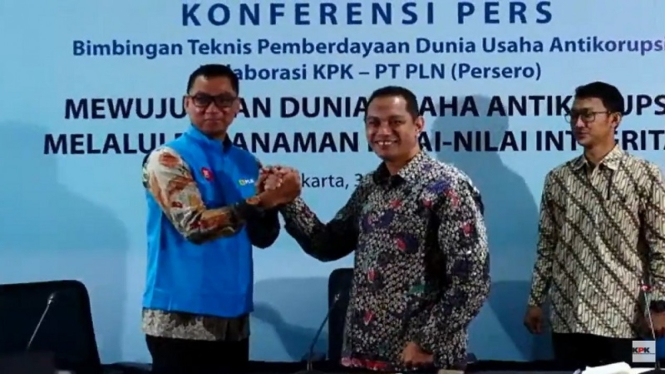 Wakil Ketua KPK Nuru Ghufron memakaikan rompi biru ke Dirut PLN