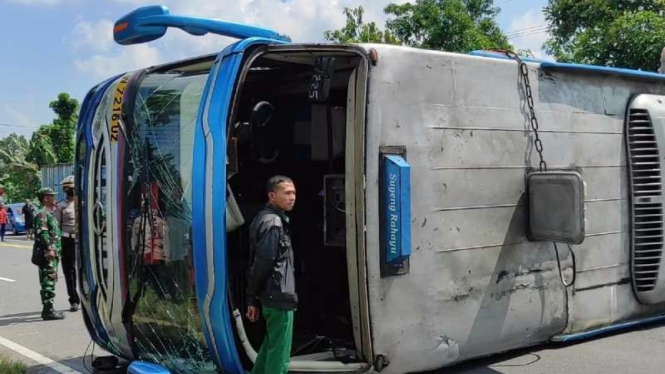 Badan bus Sugeng Rahayu melintangi badan jalan.