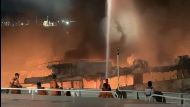Petugas gabungan mencoba memadamkan api dari kapal yang terbakar