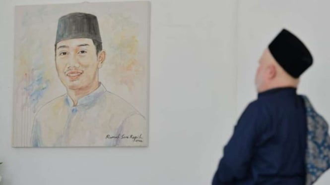 Seorang warga menatap lukisan putra sulung Gubernur Jawa Barat M Ridwan Kamil, Emmeril Kahn Mumtadz, di Gedung Negara Pakuan, Kota Bandung, Minggu, 5 Juni 2022.