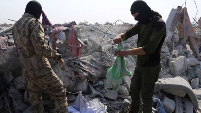 Warga mengecek di lokasi yang dihancurkan militer AS mencari ISIS tahun 2019