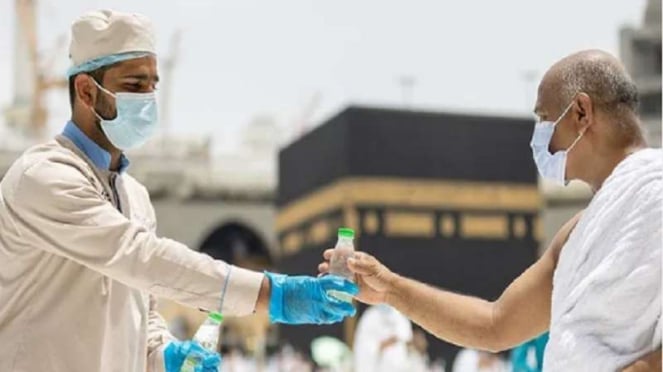 Oficiais distribuem água zamzam em garrafas aos peregrinos