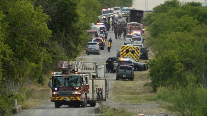 Kantong mayat tergeletak di tempat di mana sebuah trailer traktor dengan banyak mayat ditemukan di San Antonio, Amerika Serikat.