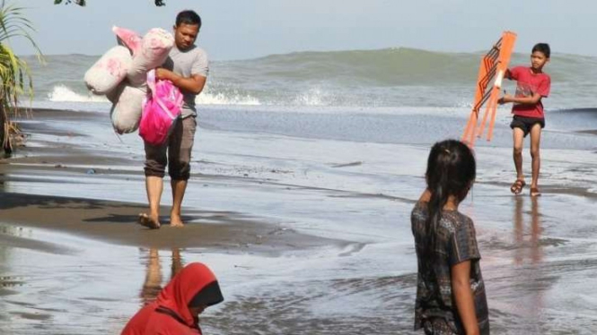 Warga menyelamatkan harta benda saat terjadinya pasang air laut di Aceh Barat.