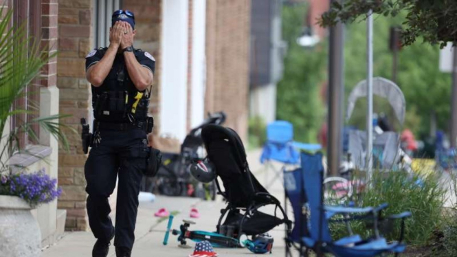 Petugas polisi berjalan di Central Ave in Highland Park, usai penembakan 4 Juli