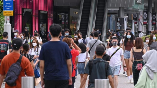 Warga menggunakan masker untuk melindungi diri dari COVID-19 di Singapura.