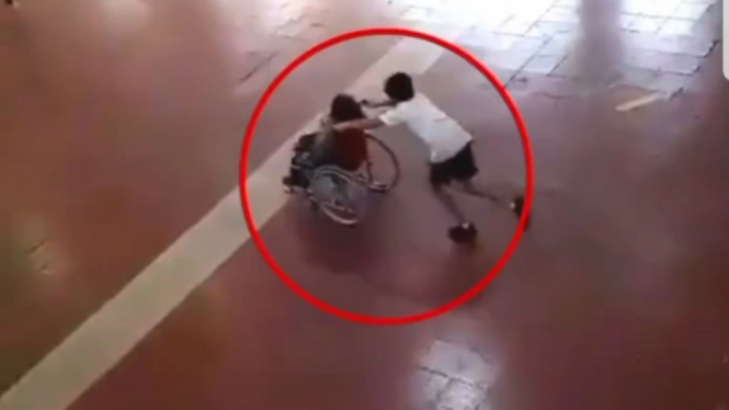 Anak bantu teman pakai kursi roda